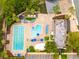Aerial view of the community pool area with ample seating, umbrellas, and meticulously kept grounds at 210 Cypress Ct # 122, Oldsmar, FL 34677