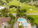Community pool with ample lounge chairs, umbrellas, and lush landscaping near a golf course at 210 Cypress Ct # 122, Oldsmar, FL 34677