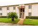 Inviting two-story condo featuring a well-maintained lawn and easy access stairs leading to the front door at 210 Cypress Ct # 122, Oldsmar, FL 34677