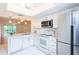 Bright kitchen features white cabinetry, stainless steel appliances, and tile flooring at 210 Cypress Ct # 122, Oldsmar, FL 34677