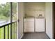 Enclosed laundry area features a full-size washer and dryer near a balcony at 210 Cypress Ct # 122, Oldsmar, FL 34677