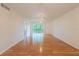 Spacious living room with gleaming hardwood floors and a glass sliding door leading to a balcony at 210 Cypress Ct # 122, Oldsmar, FL 34677