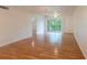 Open-concept living room featuring hardwood floors and sliding glass doors to the balcony at 210 Cypress Ct # 122, Oldsmar, FL 34677