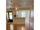Open concept with wood-look flooring, ceiling fan, and a view into the kitchen at 210 Cypress Ct # 122, Oldsmar, FL 34677