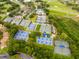 Aerial view of well-maintained tennis courts with lush green landscaping, near a community pool, and a golf course at 210 Cypress Ct # 122, Oldsmar, FL 34677