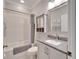 This bathroom features a shower-tub combo, white subway tile, and a vanity with granite countertops at 215 Sela Cove Cir, Apollo Beach, FL 33572