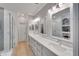 Bright bathroom with dual sinks, large mirrors and tiled walk-in shower at 215 Sela Cove Cir, Apollo Beach, FL 33572
