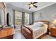 A modern bedroom with a queen bed, sleek grey walls, and two windows for ample natural light and brightness at 215 Sela Cove Cir, Apollo Beach, FL 33572