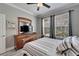 A modern bedroom with a queen bed, sleek grey walls, and two windows for ample natural light and brightness at 215 Sela Cove Cir, Apollo Beach, FL 33572