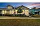 Charming home with a screened porch and colorful landscaping, offering great curb appeal at sunset at 215 Sela Cove Cir, Apollo Beach, FL 33572