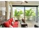 Relaxing sunroom featuring comfortable seating and views of lush, tropical landscaping at 215 Sela Cove Cir, Apollo Beach, FL 33572