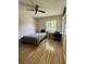 Bedroom featuring natural light, wood laminate flooring, ceiling fan, and study area, offering a comfortable and versatile space at 220 Cypress Ln # 220, Oldsmar, FL 34677