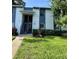Two-story condo building features blue and white facade, landscaped yard, and a welcoming entrance at 220 Cypress Ln # 220, Oldsmar, FL 34677