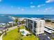 Beautiful aerial view of condos, pool, and coastline under a sunny sky at 2530 Gary Cir # 301, Dunedin, FL 34698