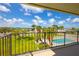Balcony view of the pool area with lush green lawns and palm trees at 2530 Gary Cir # 301, Dunedin, FL 34698