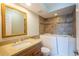 Bathroom with a walk-in bathtub, wood vanity with granite countertop and a decorative gold mirror at 2530 Gary Cir # 301, Dunedin, FL 34698