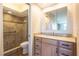 Bathroom featuring a tile shower with grab bars, wood vanity with granite countertop and a large mirror at 2530 Gary Cir # 301, Dunedin, FL 34698