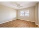 Bright bedroom with wood floors, ceiling fan, and a window with view of nearby buildings at 2530 Gary Cir # 301, Dunedin, FL 34698