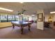 Game room with pool table, seating area, windows with palm trees, and carpeted floors at 2530 Gary Cir # 301, Dunedin, FL 34698