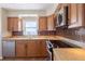 Kitchen with brown cabinets, granite countertops, and stainless steel appliances at 2530 Gary Cir # 301, Dunedin, FL 34698