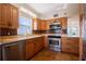 Kitchen with granite countertops, brown cabinets, and stainless steel appliances at 2530 Gary Cir # 301, Dunedin, FL 34698
