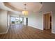 Bright, open living area with wood floors, stylish chandelier, and access to the balcony at 2530 Gary Cir # 301, Dunedin, FL 34698