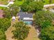 Aerial view showcasing the property layout with pool, shed, garden, trees, and lawn at 3041 Waterfall Dr, Spring Hill, FL 34608