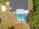 Aerial view of a backyard with a screened-in pool, patio area, and green landscaping at 3041 Waterfall Dr, Spring Hill, FL 34608
