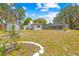 Backyard featuring a shed, home exterior, pool, and well-maintained lawn at 3041 Waterfall Dr, Spring Hill, FL 34608