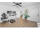 Versatile home office/bedroom with sleek workstation, modern ceiling fan, and wood-look flooring at 3041 Waterfall Dr, Spring Hill, FL 34608
