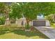 Charming home with a well-maintained lawn, mature tree, and an attached two-car garage at 3041 Waterfall Dr, Spring Hill, FL 34608