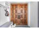 Stunning, ornate, carved, wooden double front door with sidelight and decorative hardware at 3041 Waterfall Dr, Spring Hill, FL 34608
