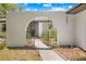 Charming front entrance features an arched gate, stucco walls, and landscaped walkway at 3041 Waterfall Dr, Spring Hill, FL 34608