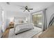Bright main bedroom featuring a ceiling fan, neutral decor, and sliding glass doors to the outdoor living space at 3041 Waterfall Dr, Spring Hill, FL 34608