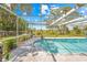 Inviting screened-in pool with views of the expansive backyard and mature trees, perfect for outdoor enjoyment at 3041 Waterfall Dr, Spring Hill, FL 34608
