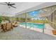 Covered patio offers a view of the screened-in pool and backyard, perfect for entertaining or relaxing outdoors at 3041 Waterfall Dr, Spring Hill, FL 34608