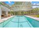 Screened-in pool with a view of the home's exterior and backyard, perfect for swimming and outdoor activities at 3041 Waterfall Dr, Spring Hill, FL 34608