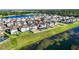 An aerial view of a neighborhood showcases a home with a screened in lanai and lake view at 3071 Marine Grass Dr, Wimauma, FL 33598