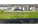 A backyard overlooks a serene pond, enclosed by a white fence for privacy and safety at 3071 Marine Grass Dr, Wimauma, FL 33598