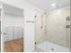Modern bathroom featuring a glass shower and a view into the walk-in closet at 3071 Marine Grass Dr, Wimauma, FL 33598