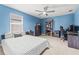 Stylish bedroom with blue walls and a comfortable sleeping and work area at 3071 Marine Grass Dr, Wimauma, FL 33598