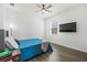 Modern bedroom with hardwood floor, ceiling fan and a mounted television at 3071 Marine Grass Dr, Wimauma, FL 33598