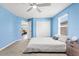 Comfortable bedroom featuring blue walls, carpet floor, and a ceiling fan at 3071 Marine Grass Dr, Wimauma, FL 33598