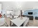 Open-concept dining room with modern table, stylish chairs, and seamless flow to the kitchen and living area at 3071 Marine Grass Dr, Wimauma, FL 33598