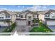 A modern two-story house showcases a beautifully landscaped yard, stone accents, and a neutral color scheme at 3071 Marine Grass Dr, Wimauma, FL 33598