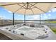 Relaxing hot tub overlooking serene water views under the shade of a large umbrella at 3071 Marine Grass Dr, Wimauma, FL 33598