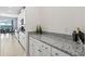 Butlers pantry featuring granite countertops, white cabinetry, and stainless steel appliances with backyard views at 3071 Marine Grass Dr, Wimauma, FL 33598