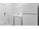 Well-equipped laundry room with washer, dryer, overhead shelving, and access door at 3071 Marine Grass Dr, Wimauma, FL 33598