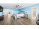 The main bedroom has light-blue walls, ensuite bathroom, and backyard views from the large windows at 3071 Marine Grass Dr, Wimauma, FL 33598