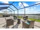 Screened-in patio with seating area and hot tub overlooking a scenic lake at 3071 Marine Grass Dr, Wimauma, FL 33598